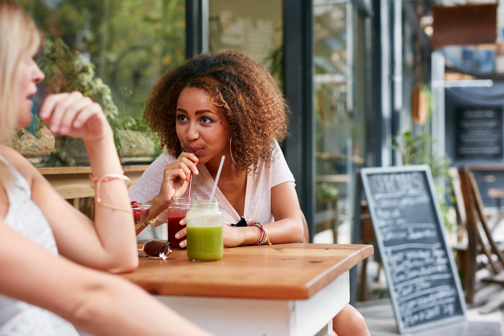 women sitting outside a coffee shop