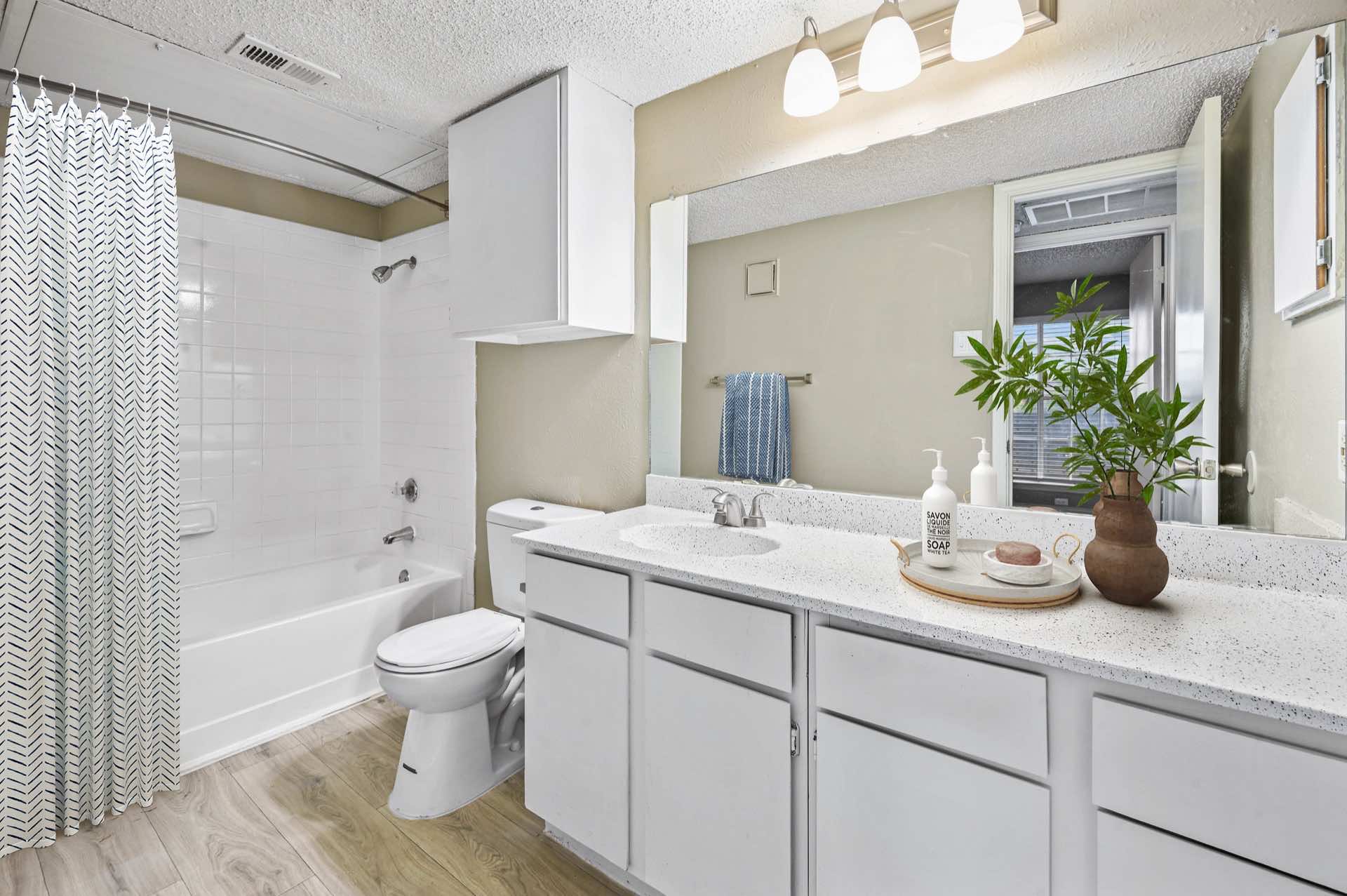 bathroom with large sink counter and shower/tub combo