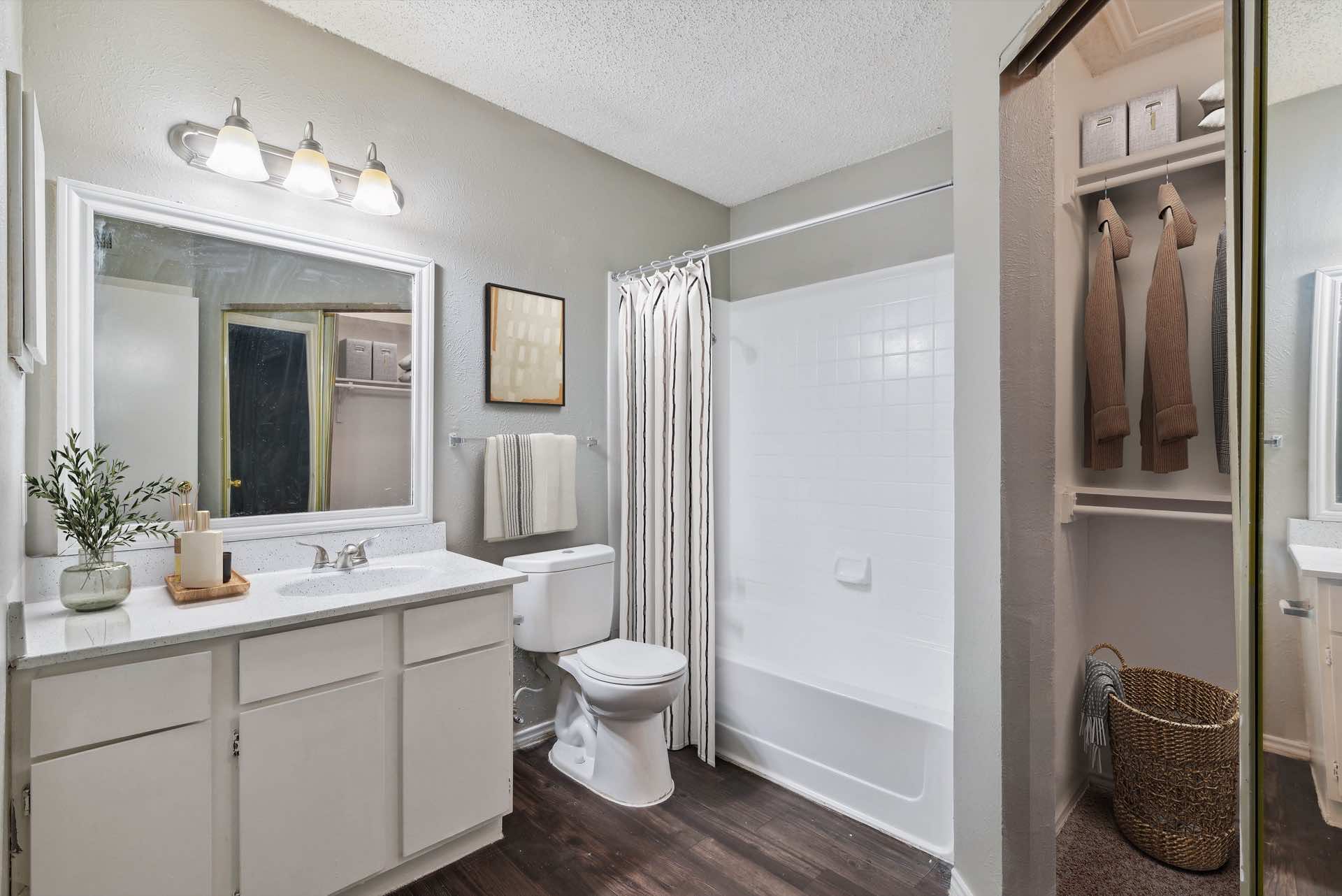 bathroom with wood-like floor and shower-tub combo
